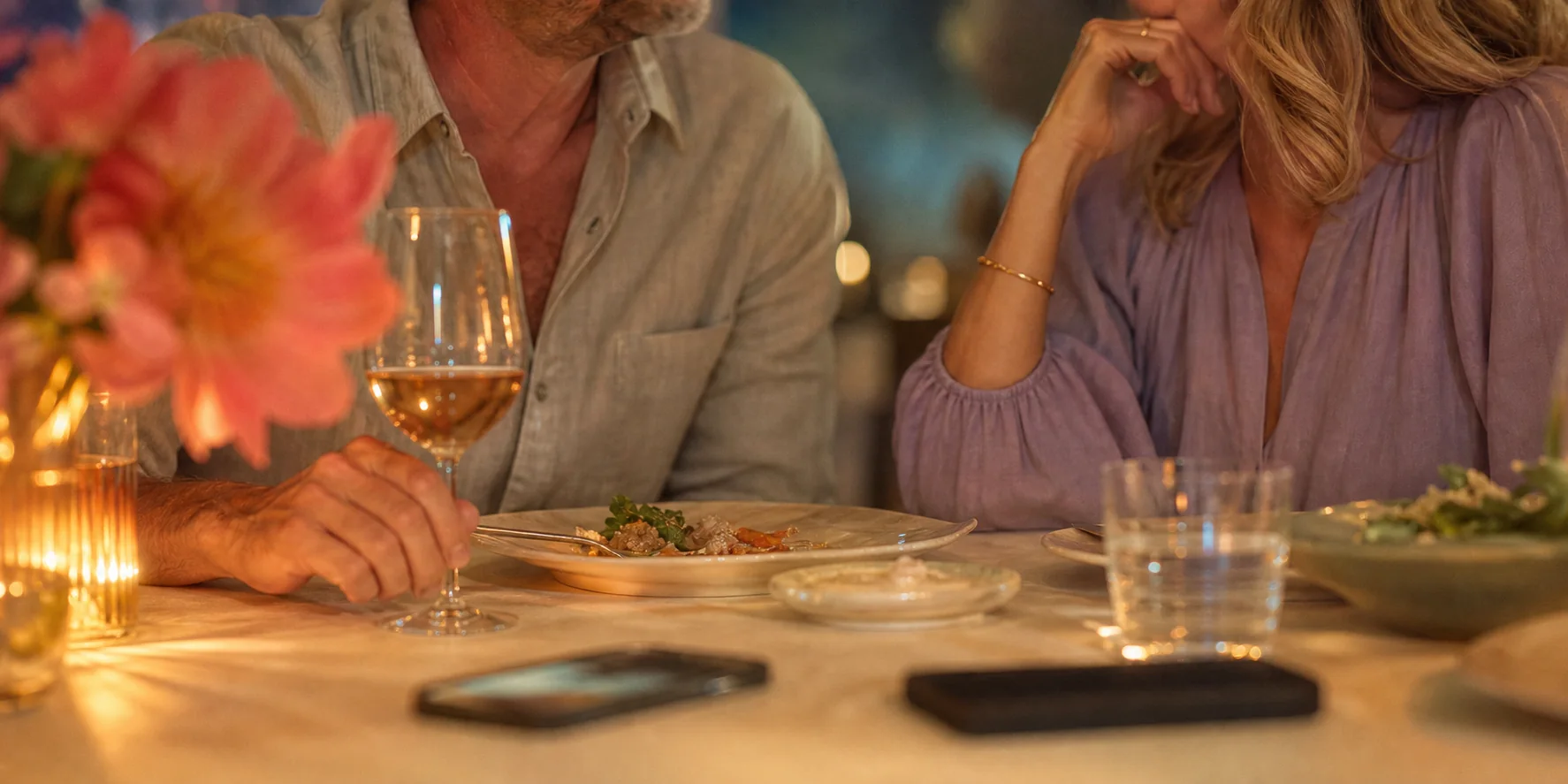 A warm dinner table moment with phones face down and a couple talking softly